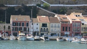 A waterfront area with colorful buildings and boats docked along the shore. - Nice apartment with sea views Son bou (Son Bou Minorca)