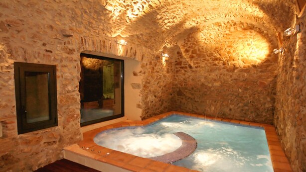 A stone-walled room with a hot tub and a wooden floor. - Rural house with pool and jacuzzi (Can Llobet - Canigó) (Capmany)