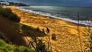 A beach with a sandy shore, a few people, and a cloudy sky. -  Typical charming residence in 400 of the beach in park sported of 4000m2 (Pornichet)