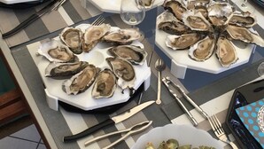 A table set with oysters, mussels, and a bottle of wine, indicating a seafood meal setup. -  Typical charming residence in 400 of the beach in park sported of 4000m2 (Pornichet)