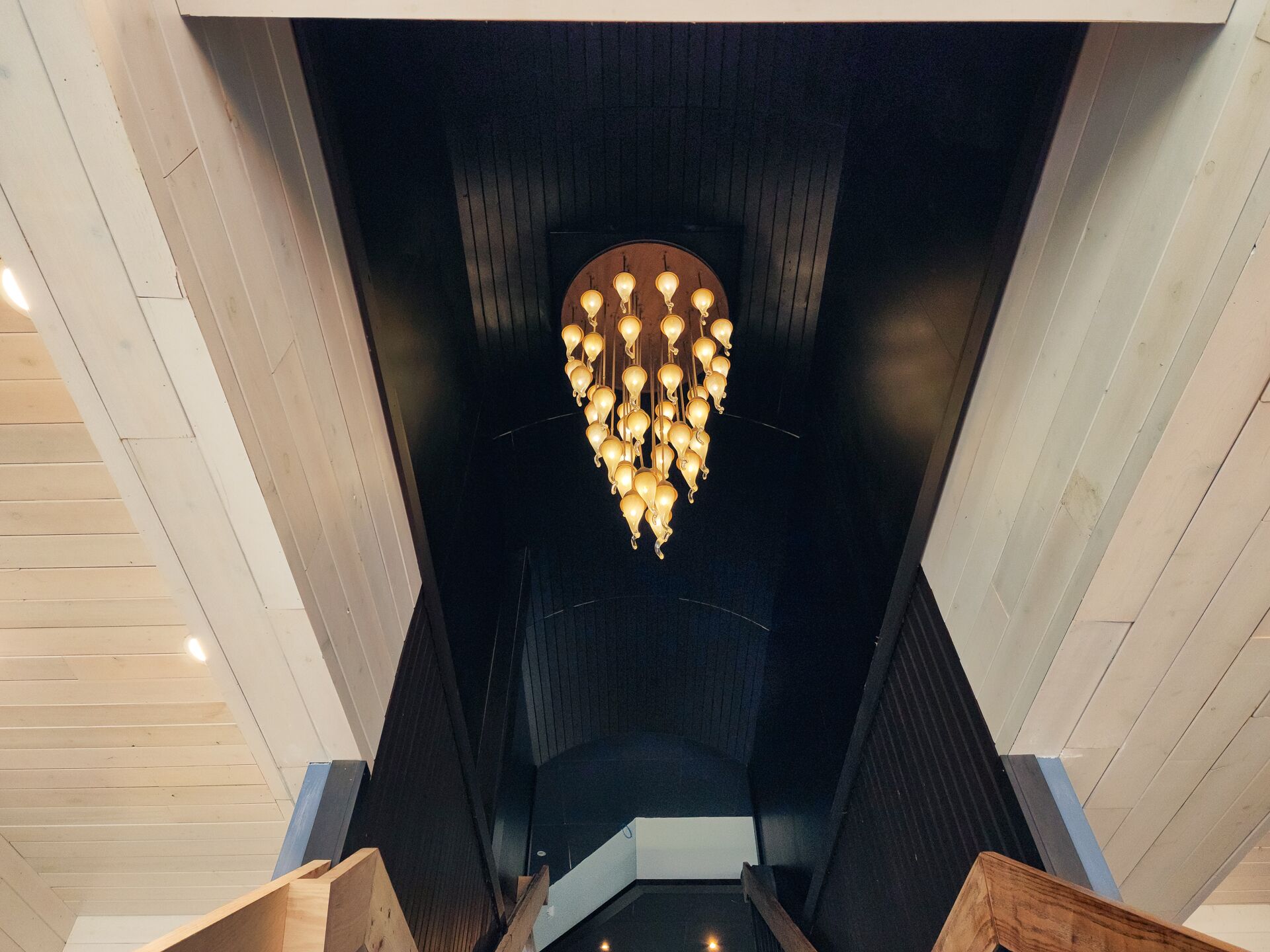 Ein modernes Interieur mit einem einzigartigen Kronleuchterdesign und Holzvertäfelung.