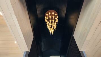 Ein modernes Interieur mit einem einzigartigen Kronleuchterdesign und Holzvertäfelung.