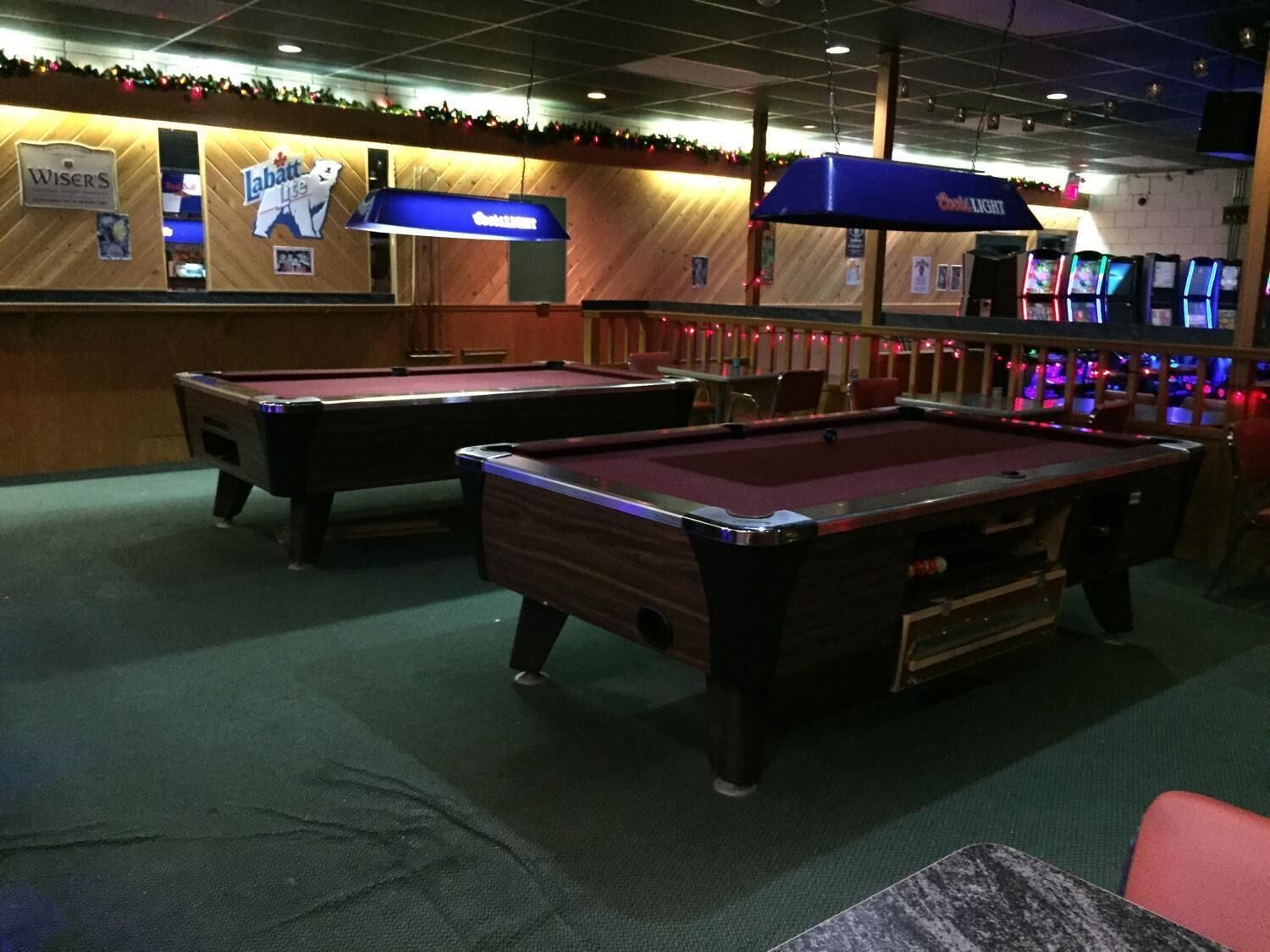 A pool table area with two pool tables, a bar area with a sign for 'Wisers' and 'Labatt Lite', and a 'The Light' sign above the bar.