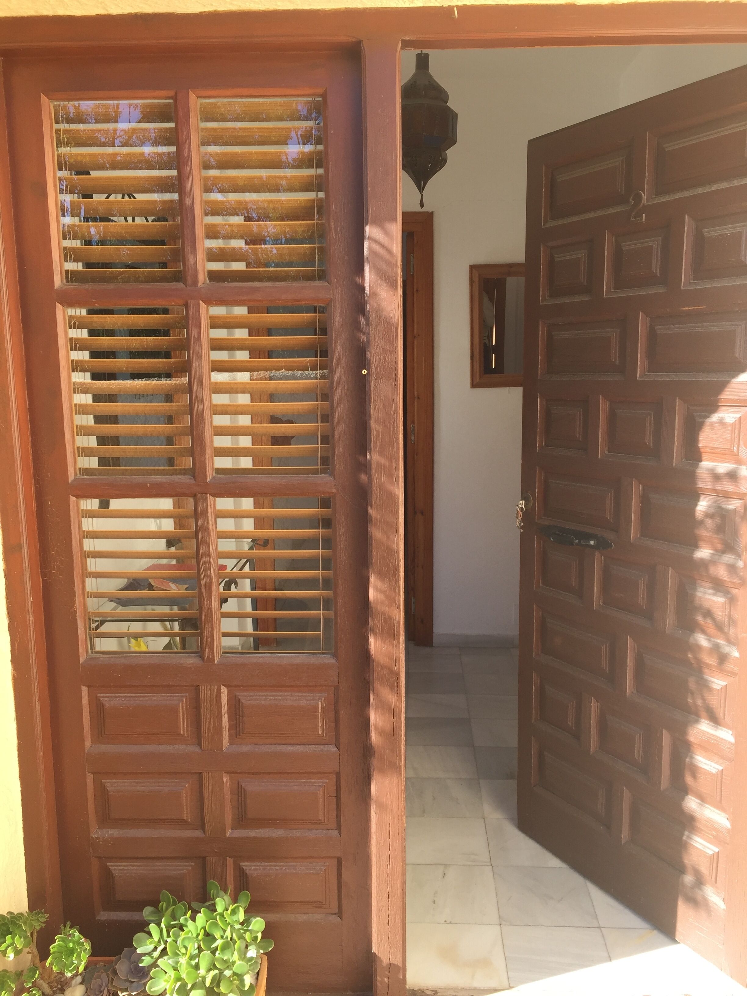 A wooden door with a glass panel and a metal handle.