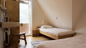 Ein Schlafzimmer mit einem Schlafpodest, einem Holztisch und einem Stuhl.