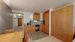 Une cuisine compacte avec des meubles en bois, un four encastré et un plan de travail en granit.