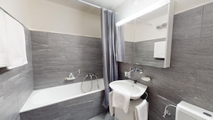 Une salle de bain moderne avec une baignoire, un lavabo et un miroir.