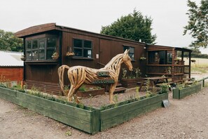 Stunning building with a horse sculpture and large windows, offering a covered porch area.