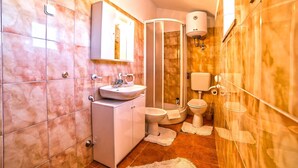 Un baño con lavabo, inodoro y ducha.