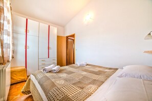 A bedroom with a bed, a wardrobe, and a door.