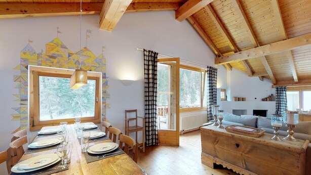 Mesa de madera para cuatro personas, con vista a los árboles.