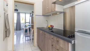 Eine moderne Küche mit Holzschränken, einer Edelstahlspüle und einem eingebauten Backofen.