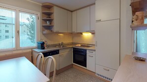 A compact kitchen with white cabinets, a built-in oven, and a dishwasher. - Very well located apartment house in the area of Park-Salet. (St. Moritz)