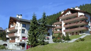 A multi-story hotel with balconies, a stone facade, and a hillside location. - Very well located apartment house in the area of Park-Salet. (St. Moritz)
