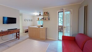 A living room with a TV, wooden furniture, a red sofa, and a bookshelf. - Very well located apartment house in the area of Park-Salet. (St. Moritz)