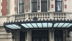 Il s’agit d’un bâtiment historique doté d’éléments architecturaux raffinés, notamment une entrée monumentale avec un double portail et un balcon décoratif.