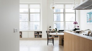 Une cuisine moderne dotée de grandes fenêtres, d’un coin repas et d’un bar.