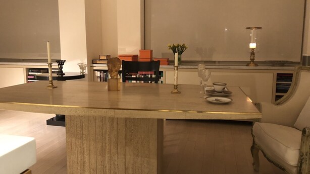 Un espace repas moderne doté d’une grande table centrale, de bibliothèques et d’un coin salon confortable.