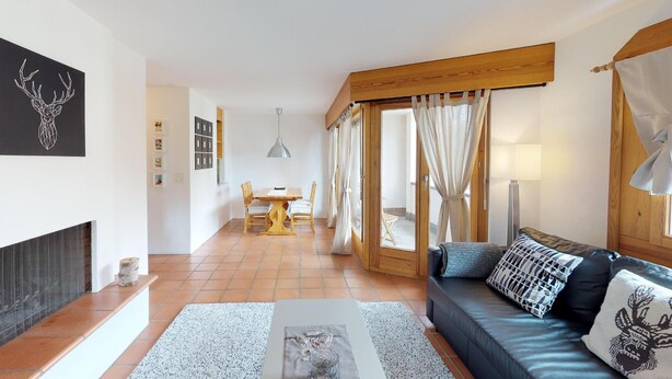 Una sala de estar moderna con un sofá, un comedor y una chimenea.