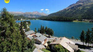 A lakeside property with multiple buildings, a road, and a mountain backdrop. - Terraced apartmentbuilding between St. (St. Moritz)