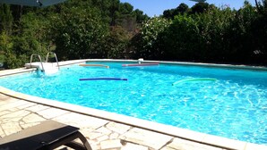 A swimming pool with clear blue water, surrounded by stone tiles and a bench. - Secular Manor: Pool & 2.5ha Estate – Perfect for Families & Friends (Roussillon)