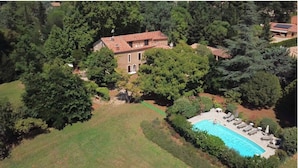 An aerial view of a house surrounded by dense trees, with a swimming pool and outdoor seating area. - Secular Manor: Pool & 2.5ha Estate – Perfect for Families & Friends (Roussillon)