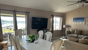 Un salon spacieux comprenant un coin repas, un canapé et un téléviseur.