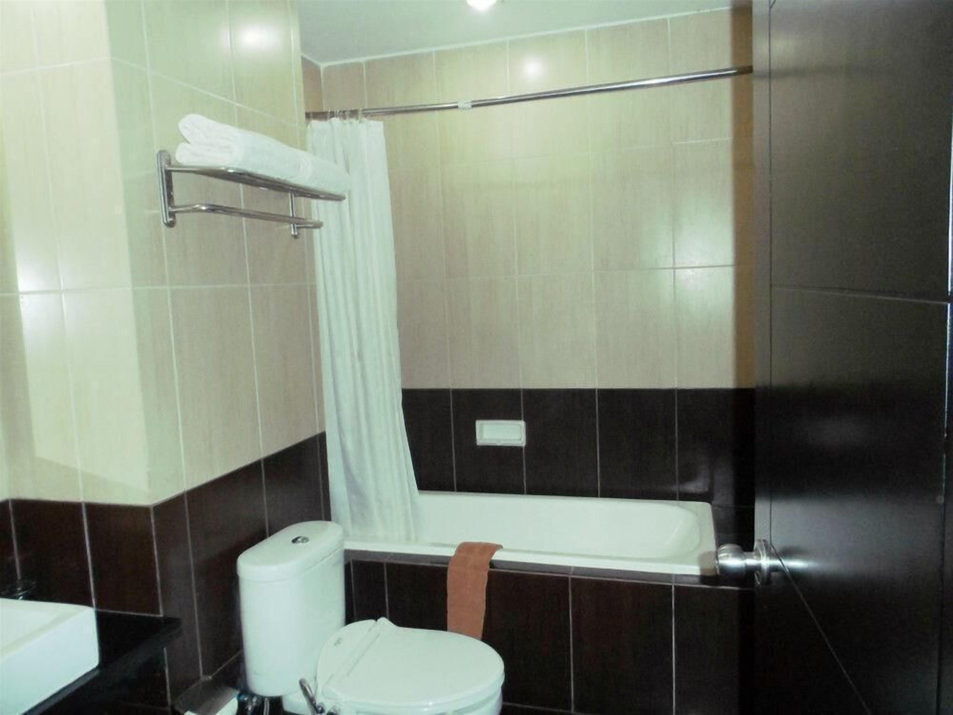 Un baño con inodoro, bañera y cortina de ducha.