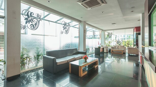 A spacious lobby with a modern sofa, a glass coffee table, and a reception desk. - Collection O Cikarang Near Pollux Mall Formerly Hotel Pesona Cikarang (Cikarang)