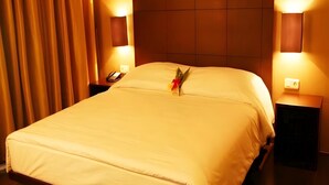 A hotel room with a large bed, two bedside tables, and a nightstand with a phone. - Collection O Cikarang Near Pollux Mall Formerly Hotel Pesona Cikarang (Cikarang)