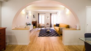 Un salon moderne avec une cheminée, un canapé et un coin repas.
