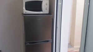 Una kitchenette compacta con microondas y refrigerador.