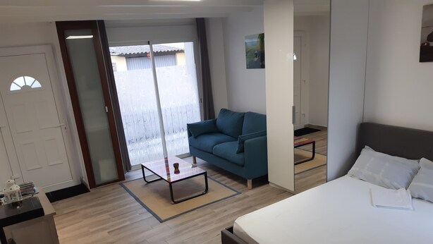 Una habitación de hotel con cama, sofá, una mesita y un escritorio.