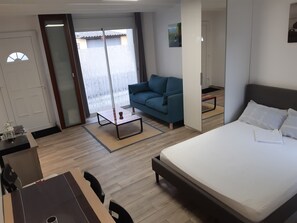 Una habitación de hotel con cama, sofá, una mesita y un escritorio.