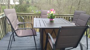 A wooden deck with a table and four chairs. - CrownCity Home Away From Home (Charlotte)