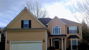 A two-story house with a garage, a front porch, and a covered entryway. - CrownCity Home Away From Home (Charlotte)
