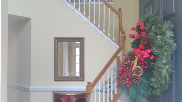 A staircase with wooden railings and a mirror on the wall. - CrownCity Home Away From Home (Charlotte)
