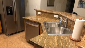 A kitchen with granite countertops, stainless steel appliances, a dishwasher, and a sink. - Very nice 4 bdrm 2 full bath ranch home w/ great room in quiet neighborhood. (Phoenix)