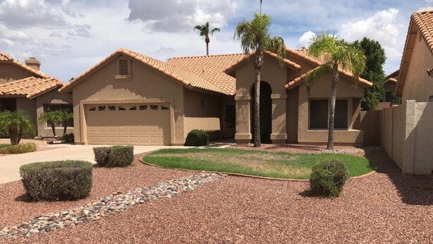 A residential area with multiple houses featuring similar architectural styles, including tiled roofs and stucco walls. - Very nice 4 bdrm 2 full bath ranch home w/ great room in quiet neighborhood. (Phoenix)