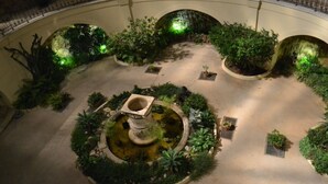 An indoor garden with a central fountain, surrounded by various plants and greenery. - LOVELY DUPLEX IN A PALACE (Beausoleil)