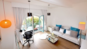 A modern living room with a sofa, coffee table, and a desk with a chair. - LOVELY DUPLEX IN A PALACE (Beausoleil)