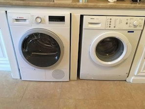 Dos lavadoras Bosch de carga frontal, una al lado de la otra, en una cocina.