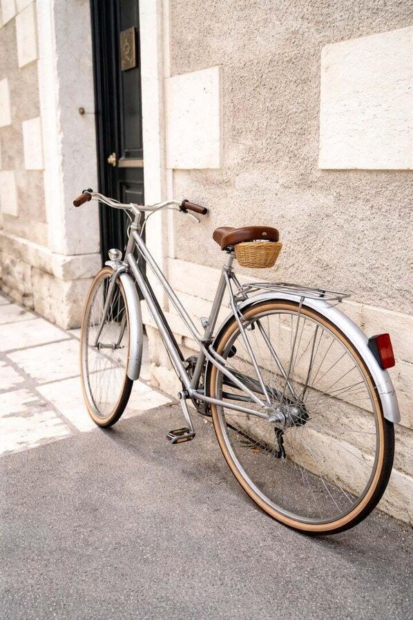 A vintage bicycle parked against a building with a stone facade.