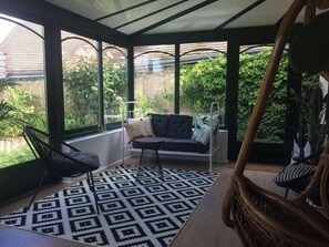 A conservatory with a black and white patterned rug, a cushioned bench, and a chair. - Large house #6 bedrooms #Near Amboise/Tours (Mosnes)