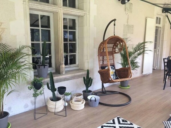 A wicker hanging chair with cushions, potted plants, and a patterned rug on a wooden floor. - Large house #6 bedrooms #Near Amboise/Tours (Mosnes)