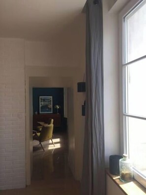 A narrow hallway with a window on the right, leading to a dining area with a chair and a table. - Large house #6 bedrooms #Near Amboise/Tours (Mosnes)