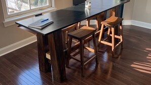 A room with a dark wooden table and two wooden stools. There are two windows with blinds, and the room has a wooden floor. - "Market View" 2Br, 2ba, Best view of the Market Square, Great Location (Knoxville)