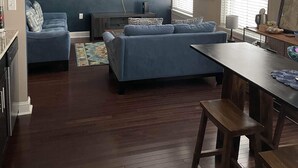 A modern living room with a flat-screen TV, a ceiling fan, and a dining area with a wooden table and benches. - "Market View" 2Br, 2ba, Best view of the Market Square, Great Location (Knoxville)