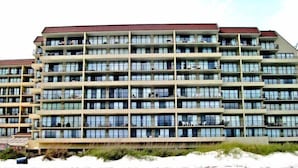 Un hotel de varios pisos con numerosos balcones y una terraza plana.