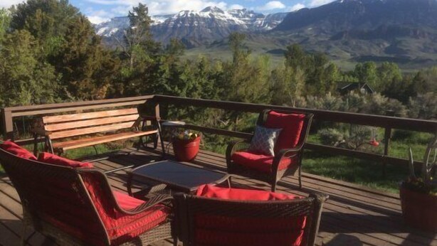 Une terrasse dotée de meubles en osier et offrant une vue sur les montagnes.